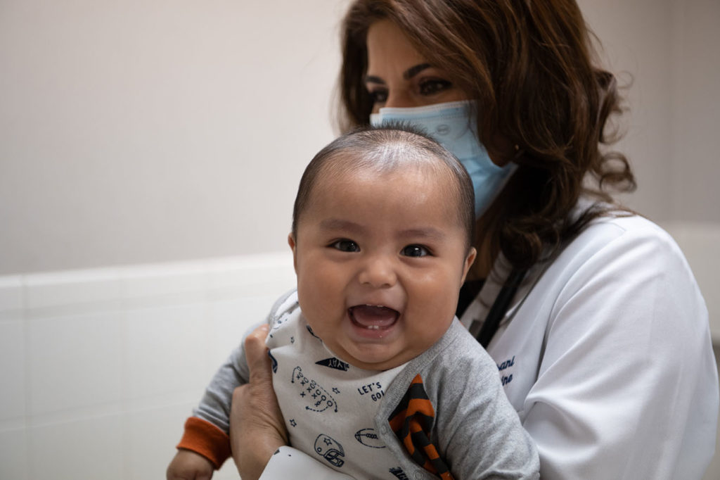 Dr. Forough Farizani performs a checkup on a baby